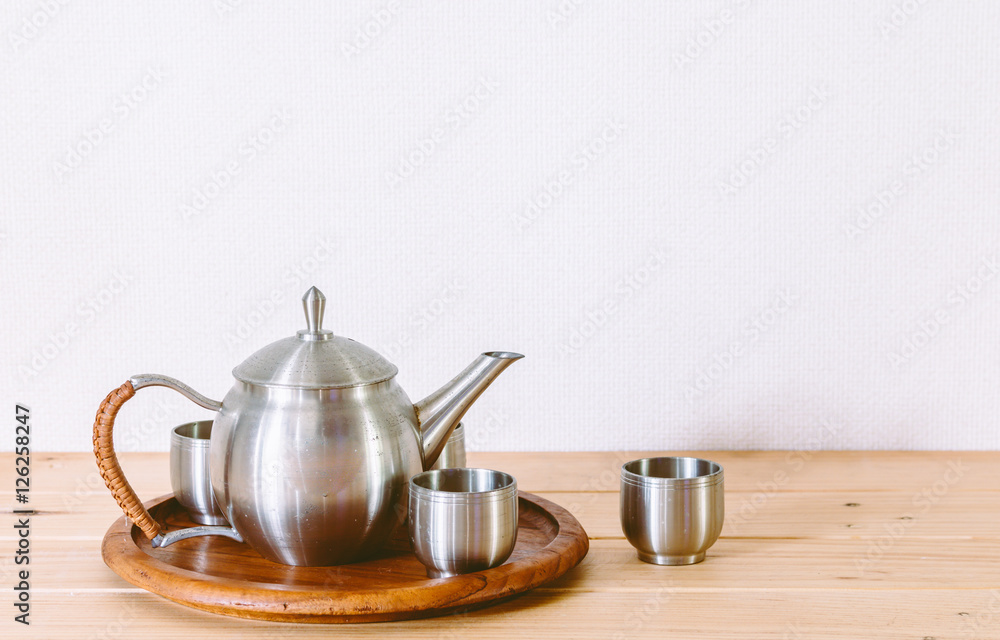 Teapot with cup of tea on wooden table Teapot with cup of tea on wooden table
