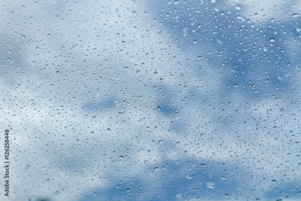 Raindrops on glass and blurred blue sky Raindrops on glass and blurred blue sky