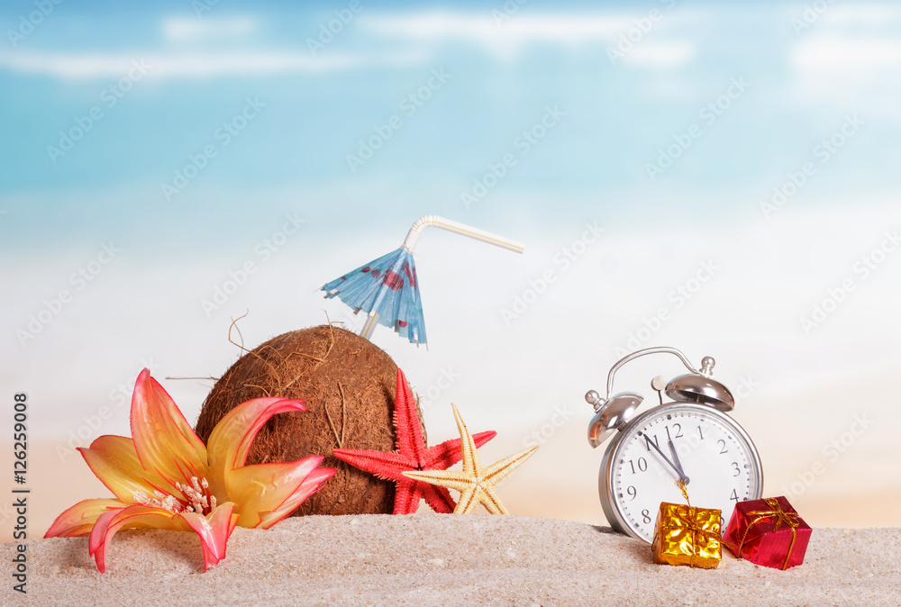 Coconut, starfish, flower, gifts alarm clock in sand against sea. Coconut, starfish, flower, gifts alarm clock in sand against sea.