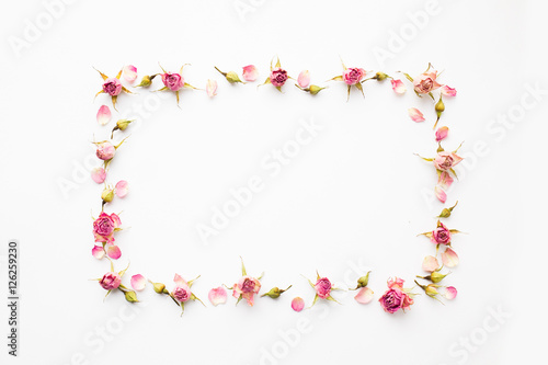 Frame made of pink dry roses and petals. Top view, greeting card.