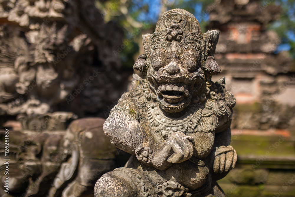 Traditional guard demon statue carved in dark stone on Bali isla Traditional guard demon statue carved in dark stone on Bali isla