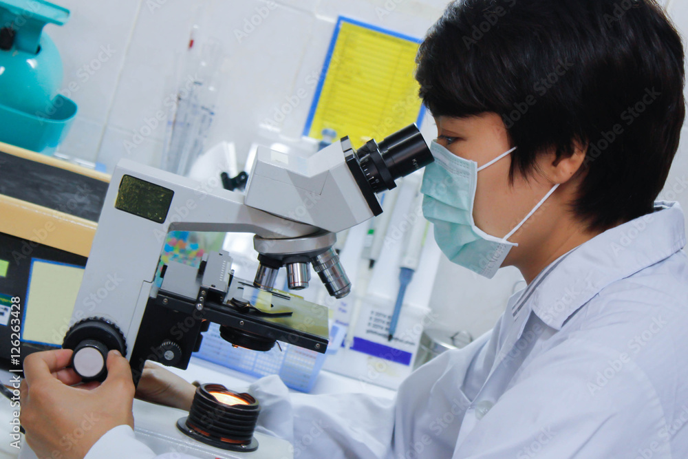 young scientist looking into microscope young scientist looking into microscope