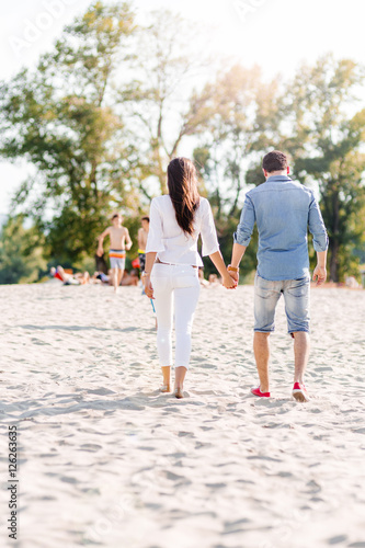 Couple holding hands and walking on a beach