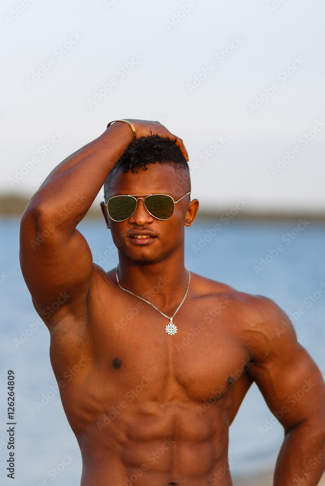 Muscular young athletic sexy man on the beach with a naked torso in  underwear. Hot black beautiful guy, fitness model with a rangy sports body.  Stock Photo | Adobe Stock