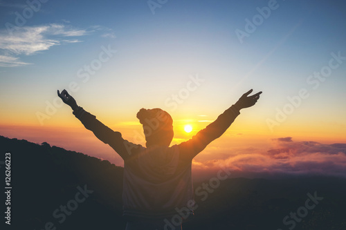 Bilde på lerret Silhouette Freedom  woman standing with raised arms and enjoying