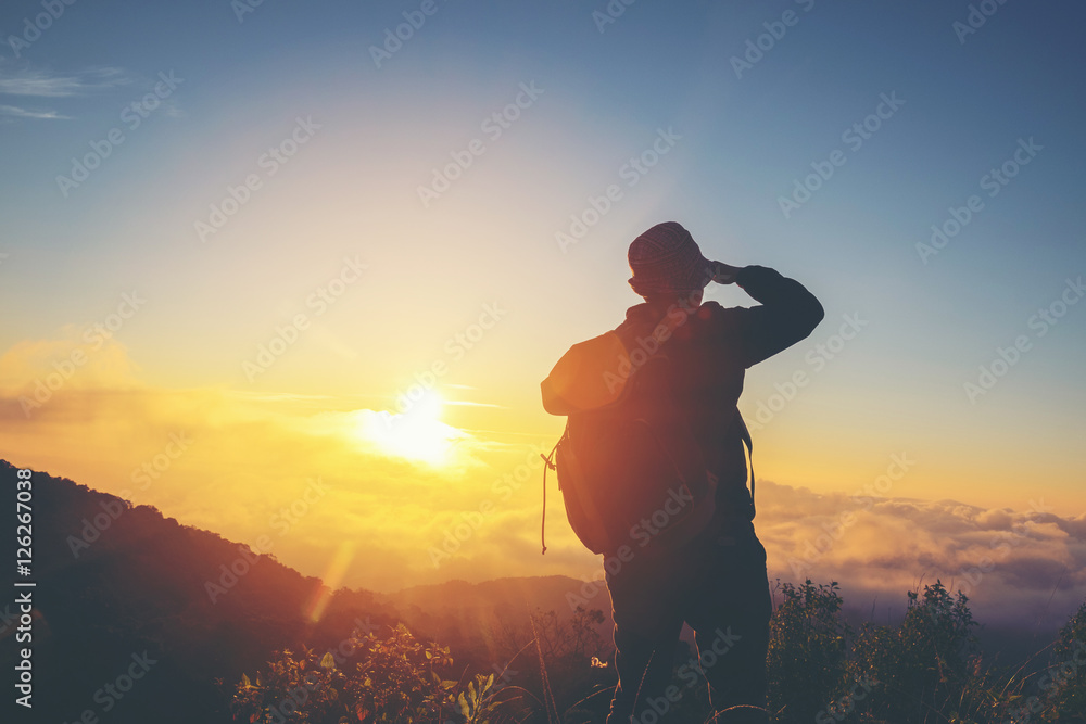 Silhouette Freedom man standing with raised arms and enjoying on