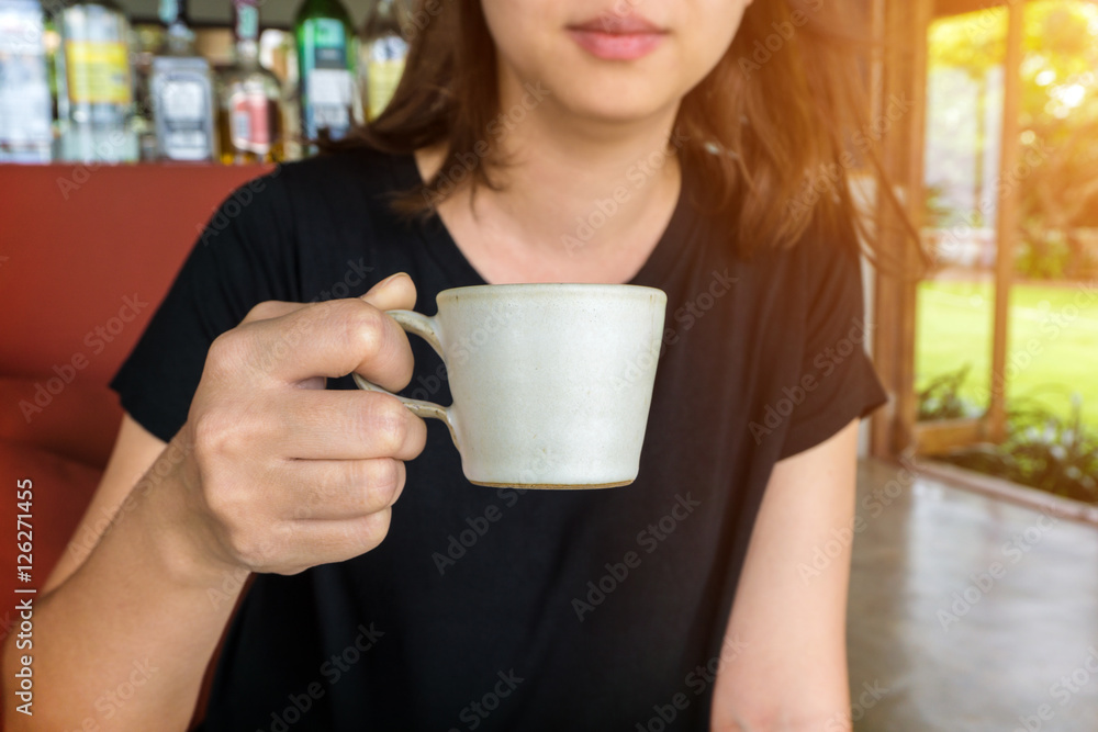 Female hand holding a cup of coffee Female hand holding a cup of coffee