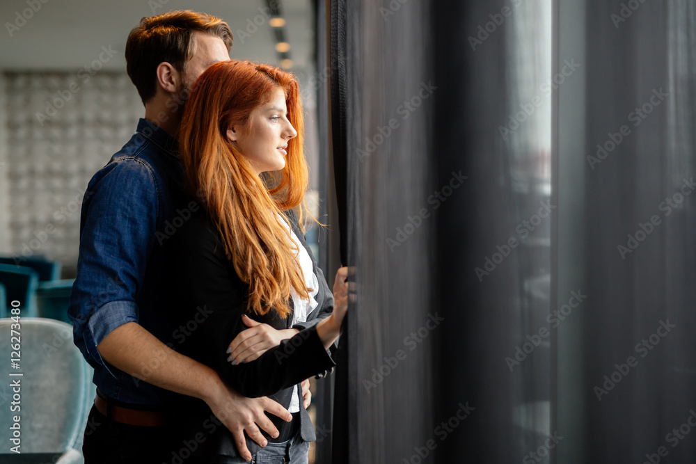 Romantic couple staring though window and daydreaming