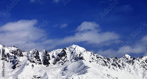 Panoramic view on snow mountains in sunny day