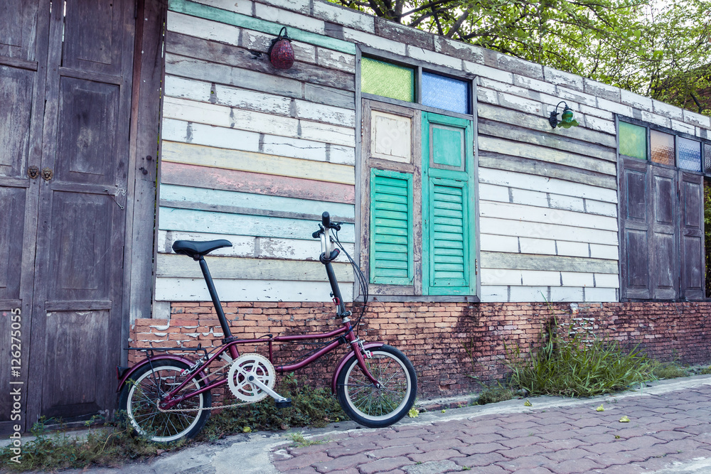 Folding Bike with old wooden wall, Vintage color.