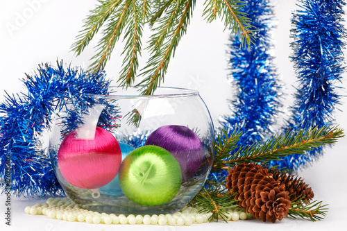 christmas balls in vase among tinsel and fir-tree brunches