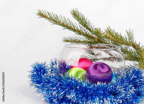 christmas balls in glass vase among tinsel on white background