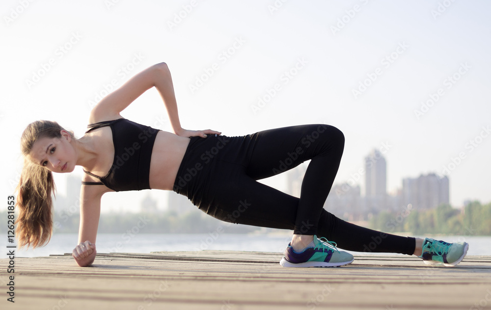 Young sporty woman doing plank exercises during training workout