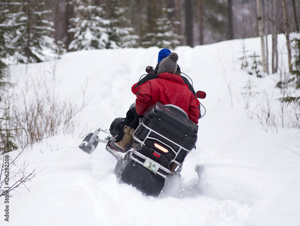 Snowmobile is accelerating in the forest