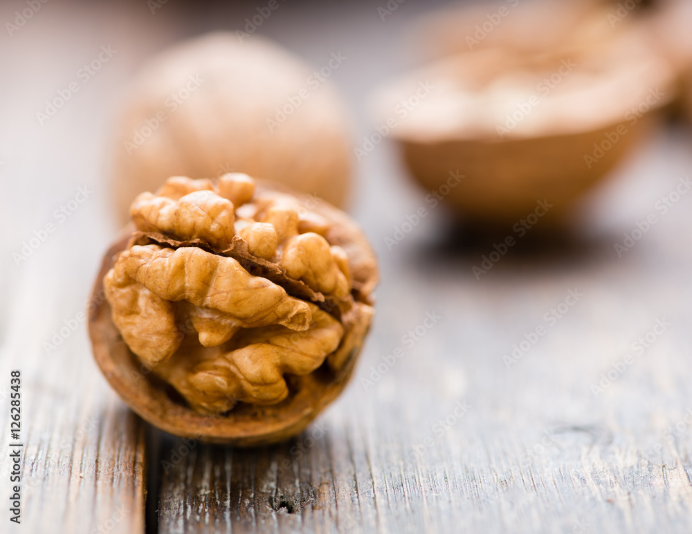 Fototapeta premium Walnuts on wooden table. Macro. Front view