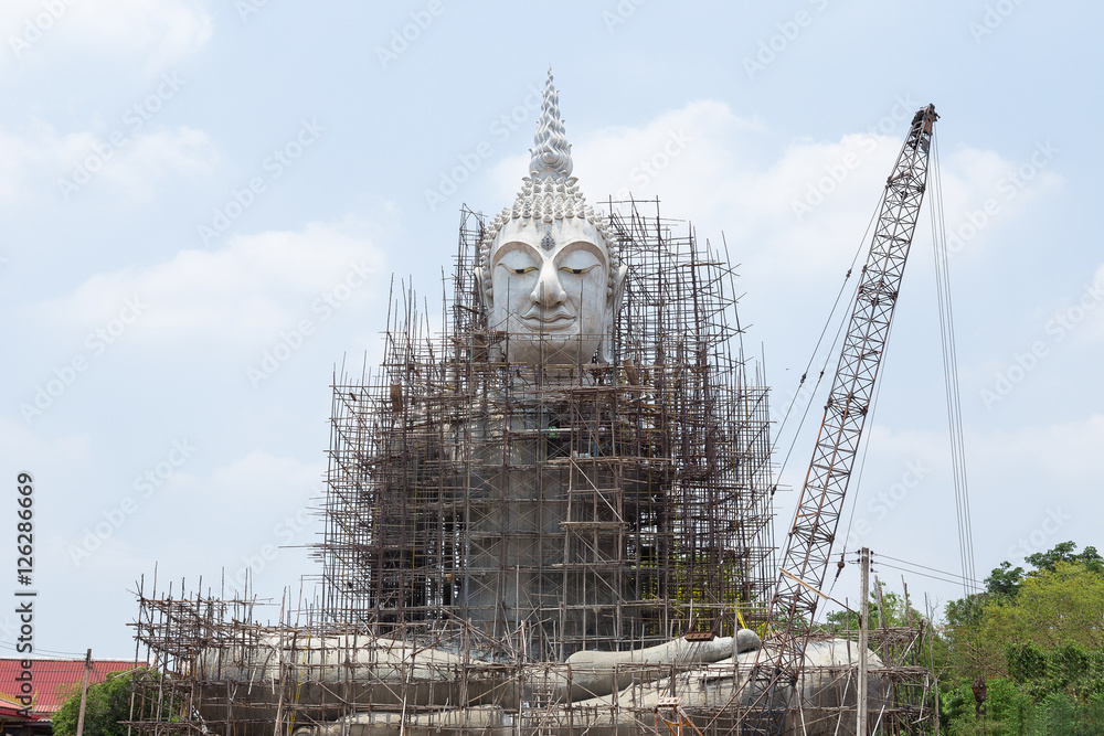 Fototapeta premium Restoration of Buddha with blue sky and white cloud, outdoor