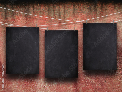 Photography Three blank blackboard frames hanged by pegs against dirty red wall background