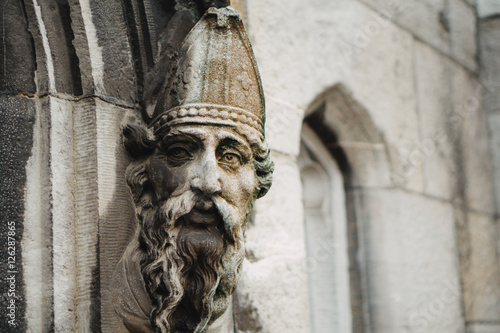 Photography Bishops face adorns a doorway.