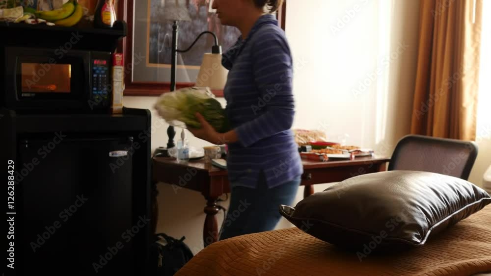 Mother cooking microwave pizzas for dinner in a hotel Mother cooking microwave pizzas for dinner in a hotel