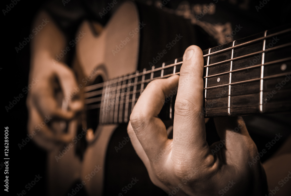 Close up hands on the strings of a guitar
