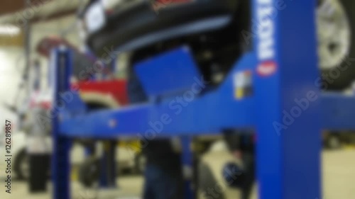 Wallpaper Mural Mechanics working underneath the car on a lift in shop Torontodigital.ca