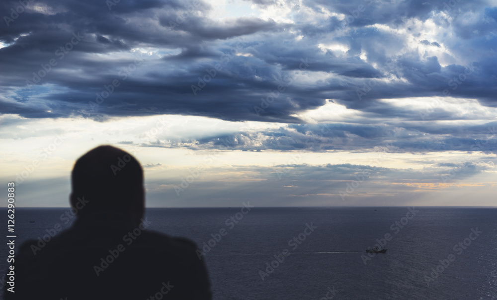 Clouds blue sky and sunlight sunset on horizon ocean Northern Spain Basque Country. Outline looking travel hipster on background seascape dramatic rays sunrise. Relax view waves sea nature