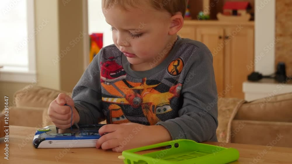 A little boy playing games on a childrens tablet A little boy playing games on a childrens tablet