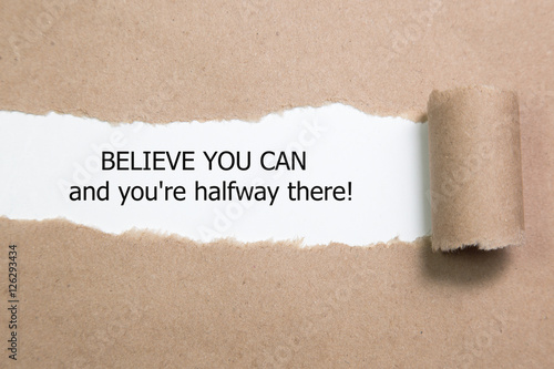 The text Believe you can and you're halfway there, appearing behind torn paper. Motivational quote.