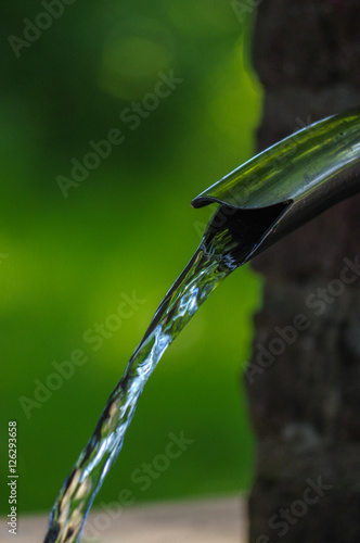 Close up of running water from a metal tap