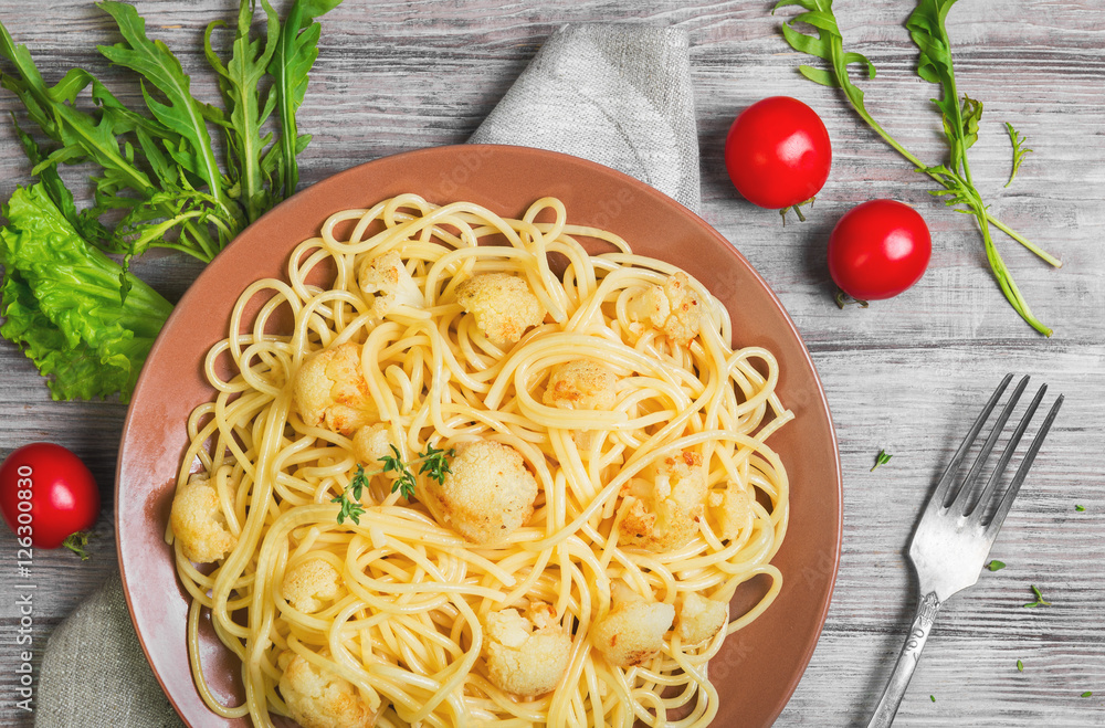 Italian pasta spaghetti on brown plate with cauliflower