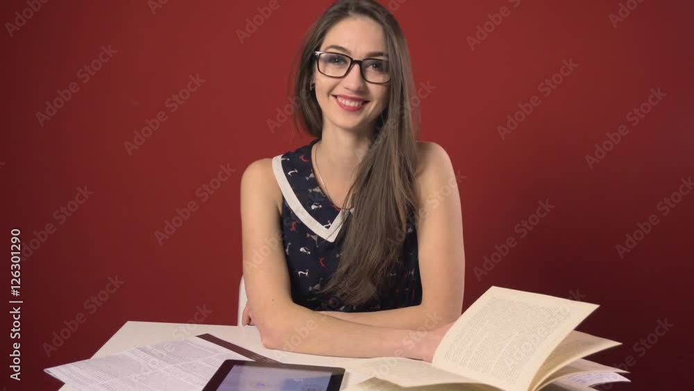 Happy successful attractive brunette student girl in glasses, table workplace with books and tablet pc Happy successful attractive brunette student girl in glasses, table workplace with books and tablet pc