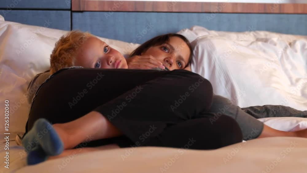 Mother and her boy in hotel room watching television