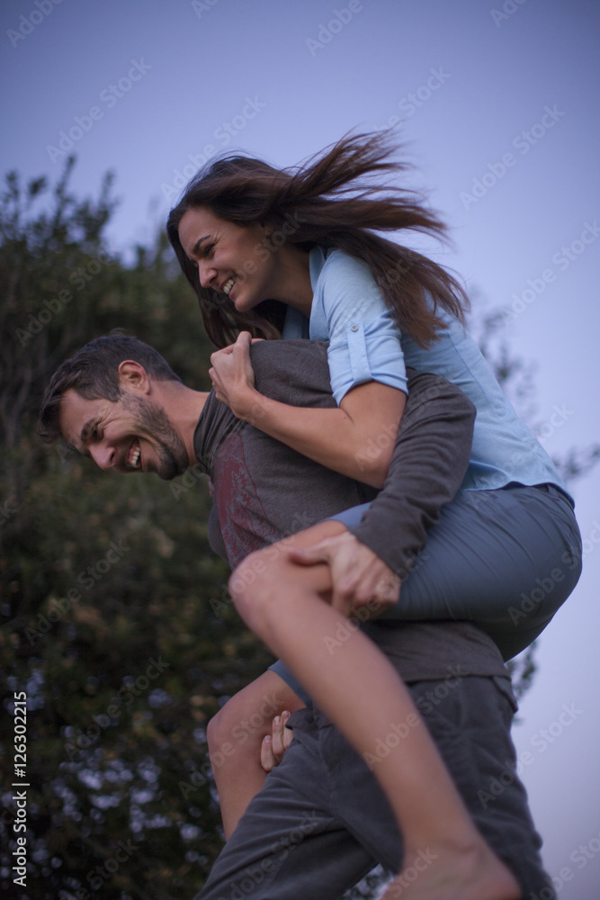 Man giving and adult woman a piggyback ride laughing and having fun in San  Diego, California. Stock Photo