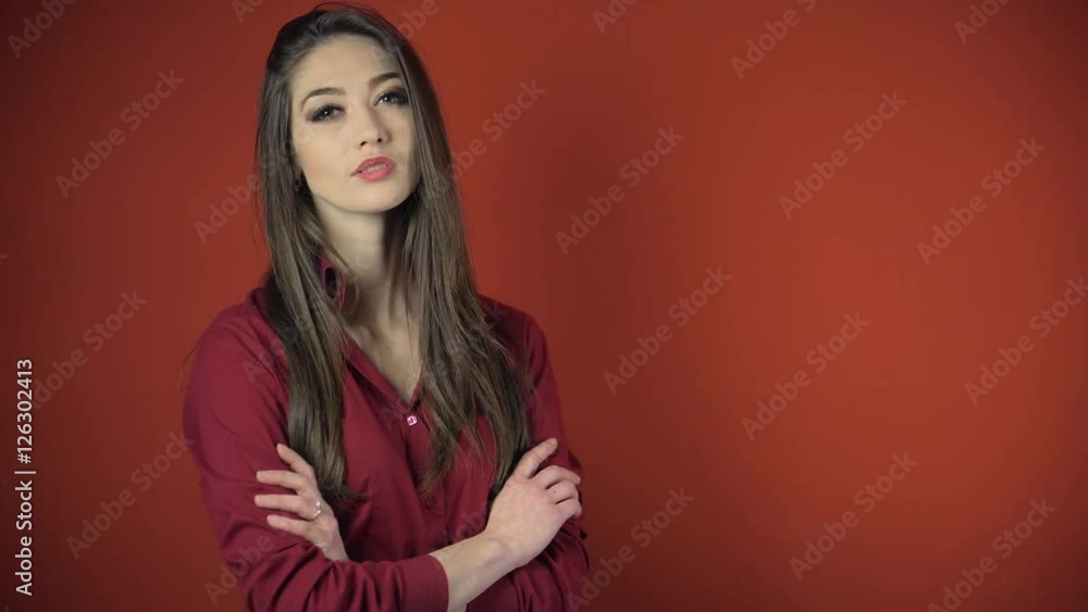 A portrait of young attractive brunette woman on red wall A portrait of young attractive brunette woman on red wall
