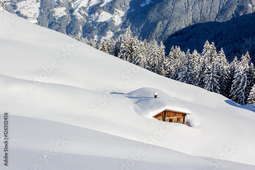 tief verschneite Schihütte in den österreichischen Alpen