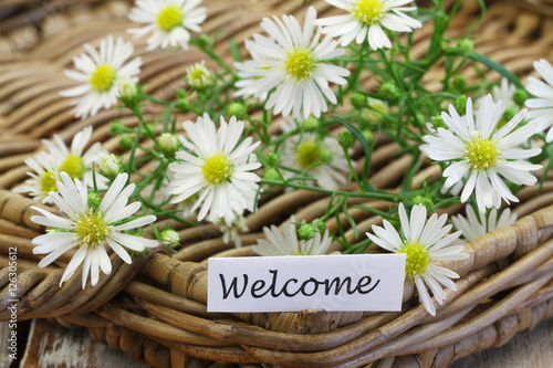 Welcome card with chamomile flowers on wicker tray
