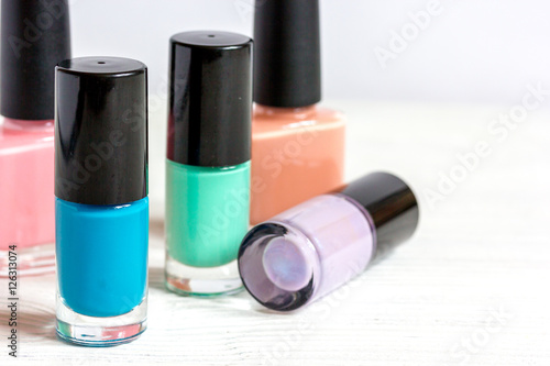 bottles of colored nail polish on wooden background close up