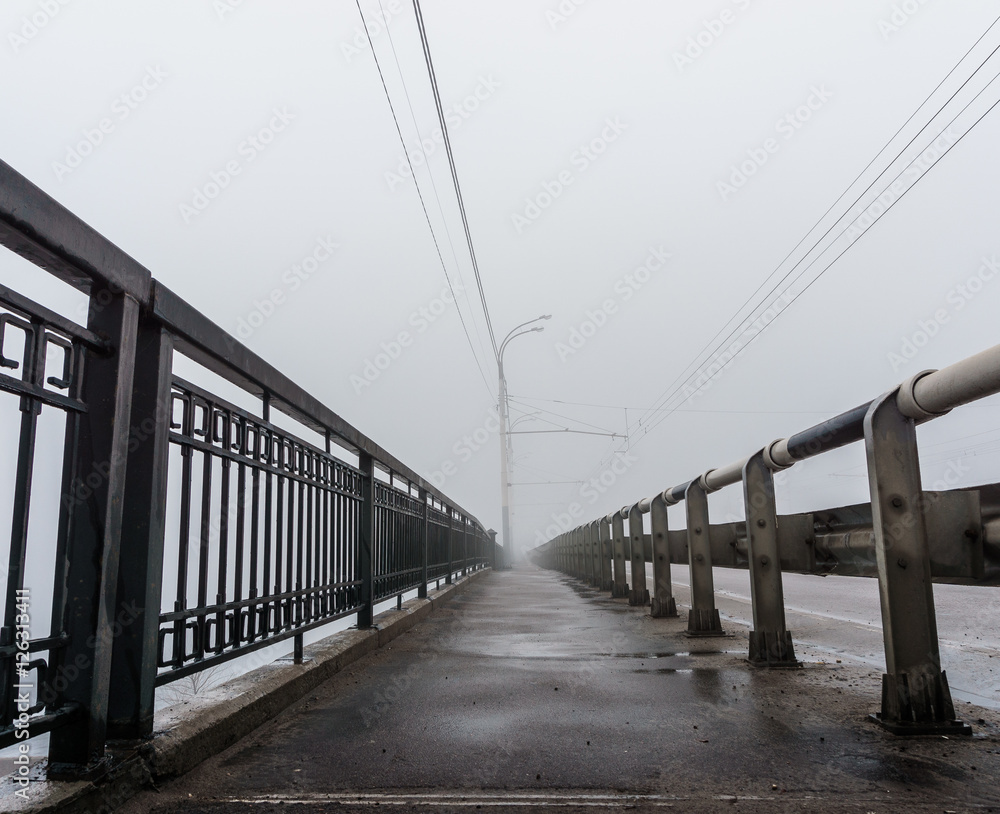 view of the pavement of the bridge in the fog, the perspective