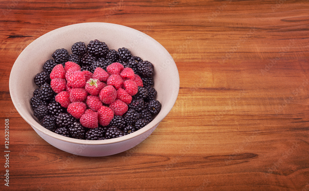 Ceramic plate with heart shaped berries on the left of the wooden table with clipping path. Top side view. Top side view. Ceramic plate with heart shaped berries on the left of the wooden table with clipping path. Top side view. Top side view.