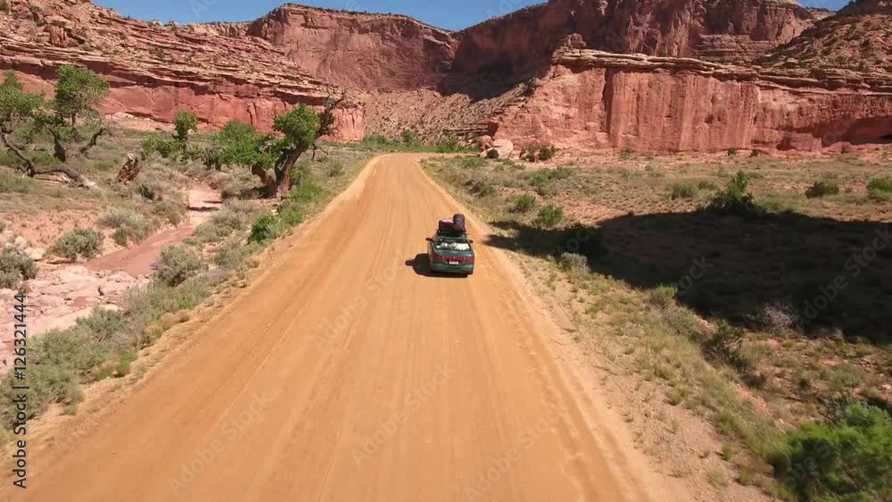 Aerial shot of car driving up desert canyon in Utah Aerial shot of car driving up desert canyon in Utah