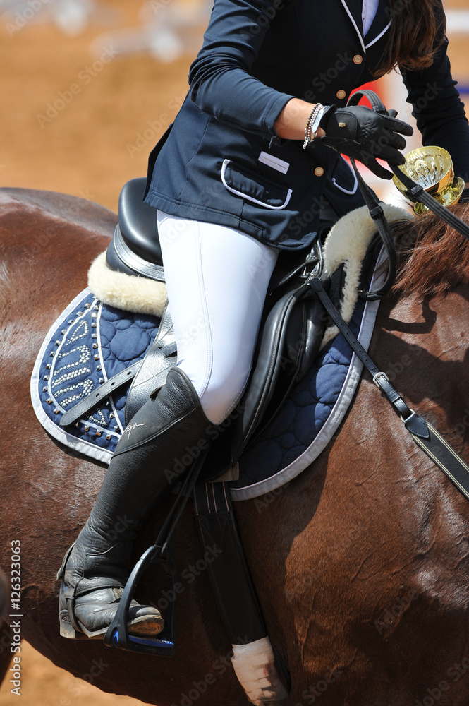 A close up view of the professional female jockey rides on horseback.
