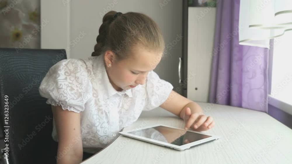 Primary schoolgirl using a digital tablet computer Primary schoolgirl using a digital tablet computer