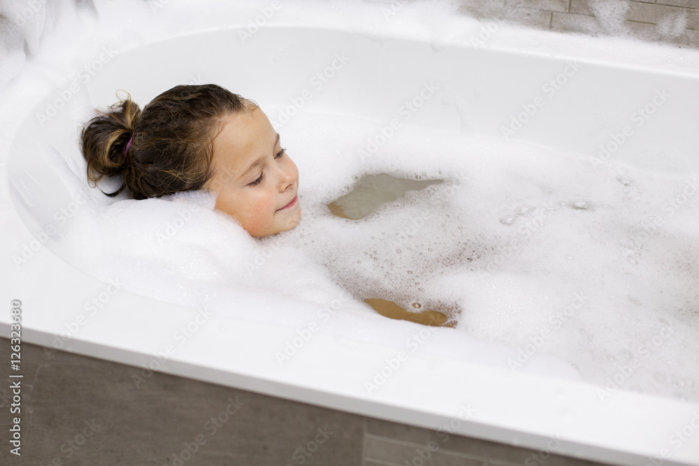 Little girl taking a bath with the foam Stock Photo