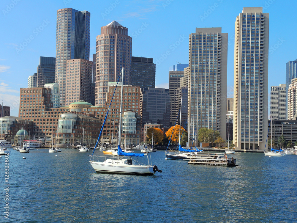 A view of the Boston skyline with boats in the foreground.