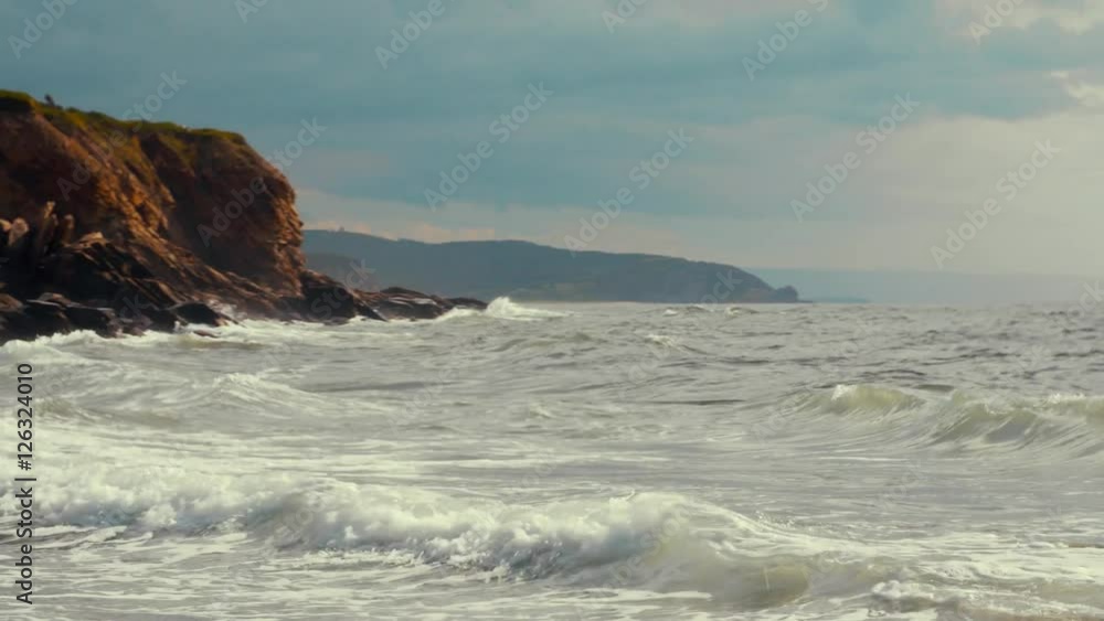 Waves crashing on a gorgeous rocky ocean coastline with cliffs Waves crashing on a gorgeous rocky ocean coastline with cliffs