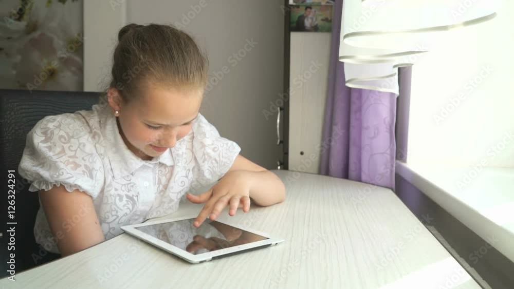 Cute little girl uses a digital tablet computer Cute little girl uses a digital tablet computer