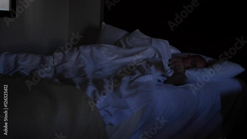 An exhasuted man asleep in a bed photo