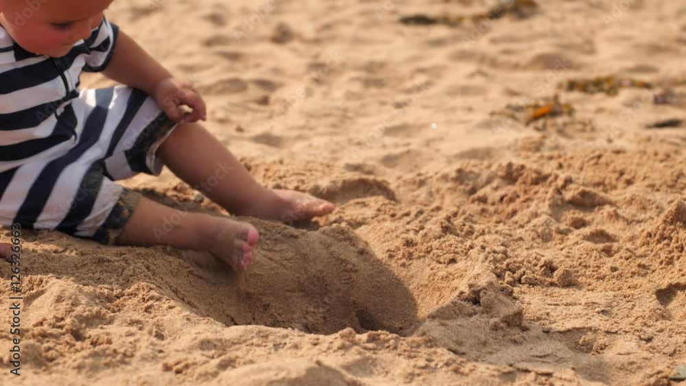 Little boy is playing on beautiful ocean beach in the sand Little boy is playing on beautiful ocean beach in the sand