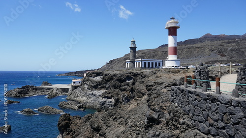 lighthouse on the cliffs with blue sky