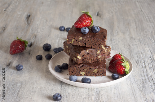 Chocolate - cherry brownie served with blueberry and strawberry 